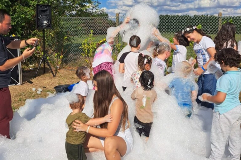 Children playing together at a Making it Mindful outdoor foam party